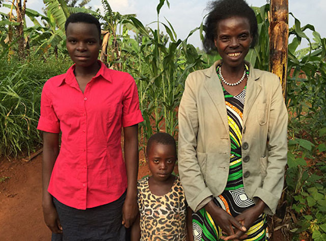 Athanasie Musabyimana standing with her children looking happy because they are not among those suffering from world hunger