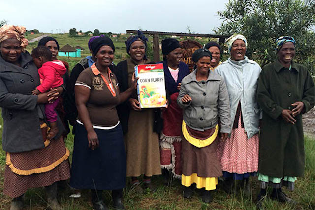 Women farmers holding final product from Kellogs that they helped contribute to produce