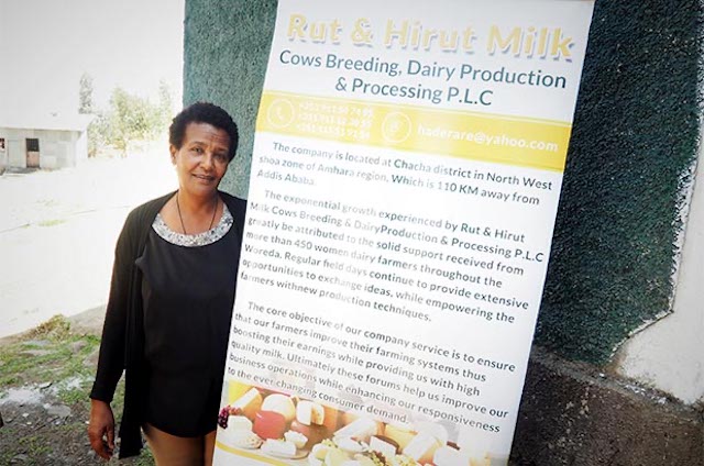 Hirut Yohannes Darare standing next to her dairy product sign in Ethiopia