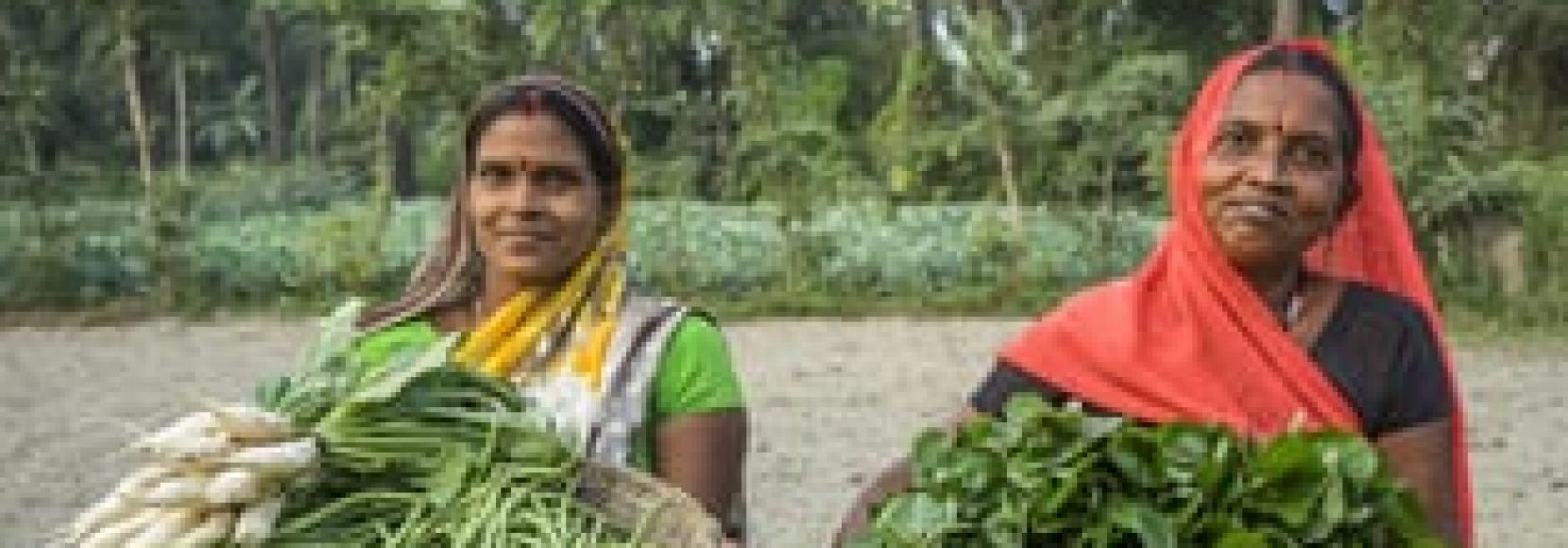 Vegetable farmers Bindu Devi and Macho Devi, members of a Farmer's Producer Group, carry their vegetables in a basket