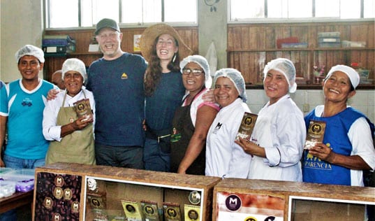 Group of people smiling holding cocoa bags