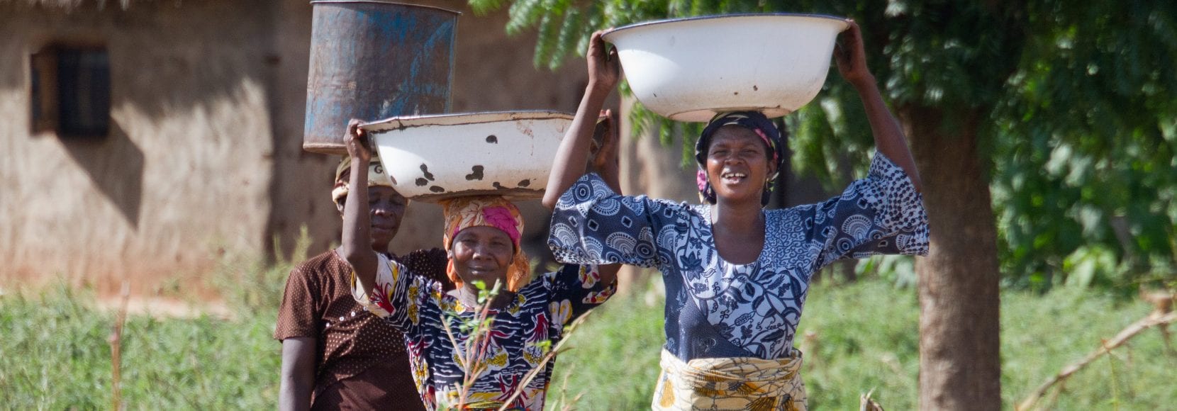 Sanatu Andani, 49, Mariama Andani, Damata Shihadu, 39 (left to right), carrying water from tap for Nyebu Be Yoona Shea Butter Processing Group, Kanfiehiyili village, Tamale, Ghana.