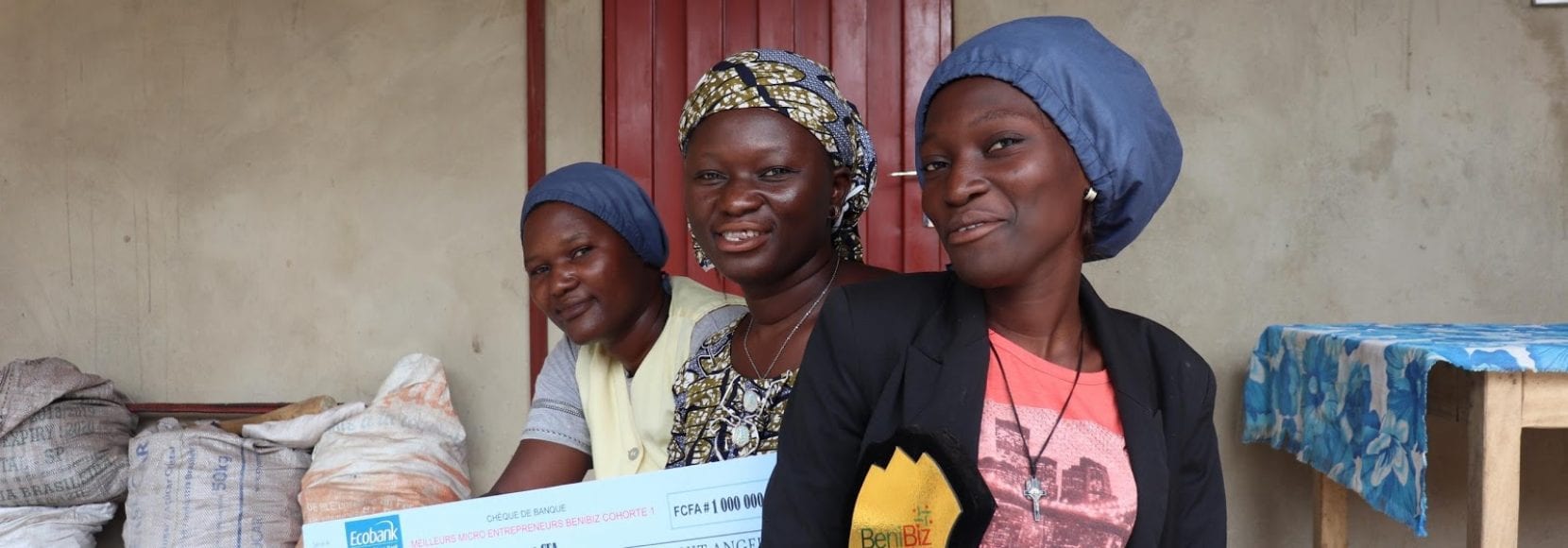 Three women in Benin smiling after receiving awards