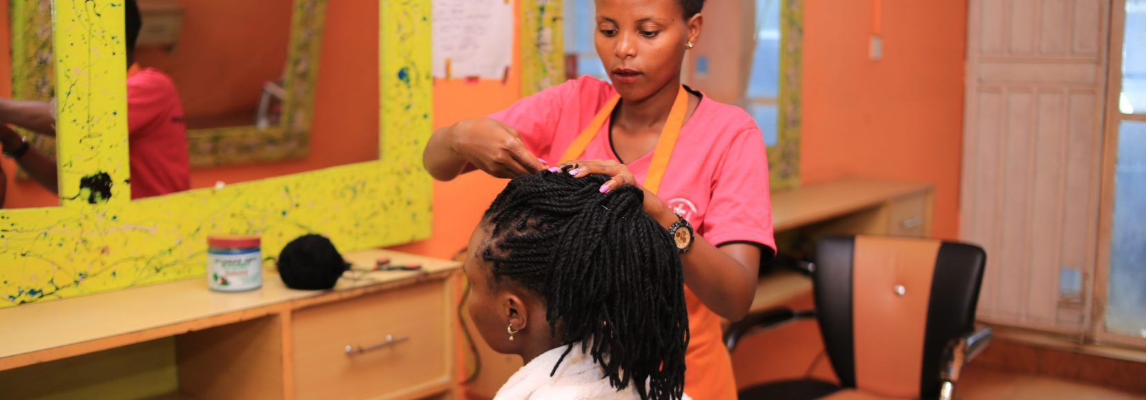 Carolyn works on a client in her salon business near Kampala, Uganda