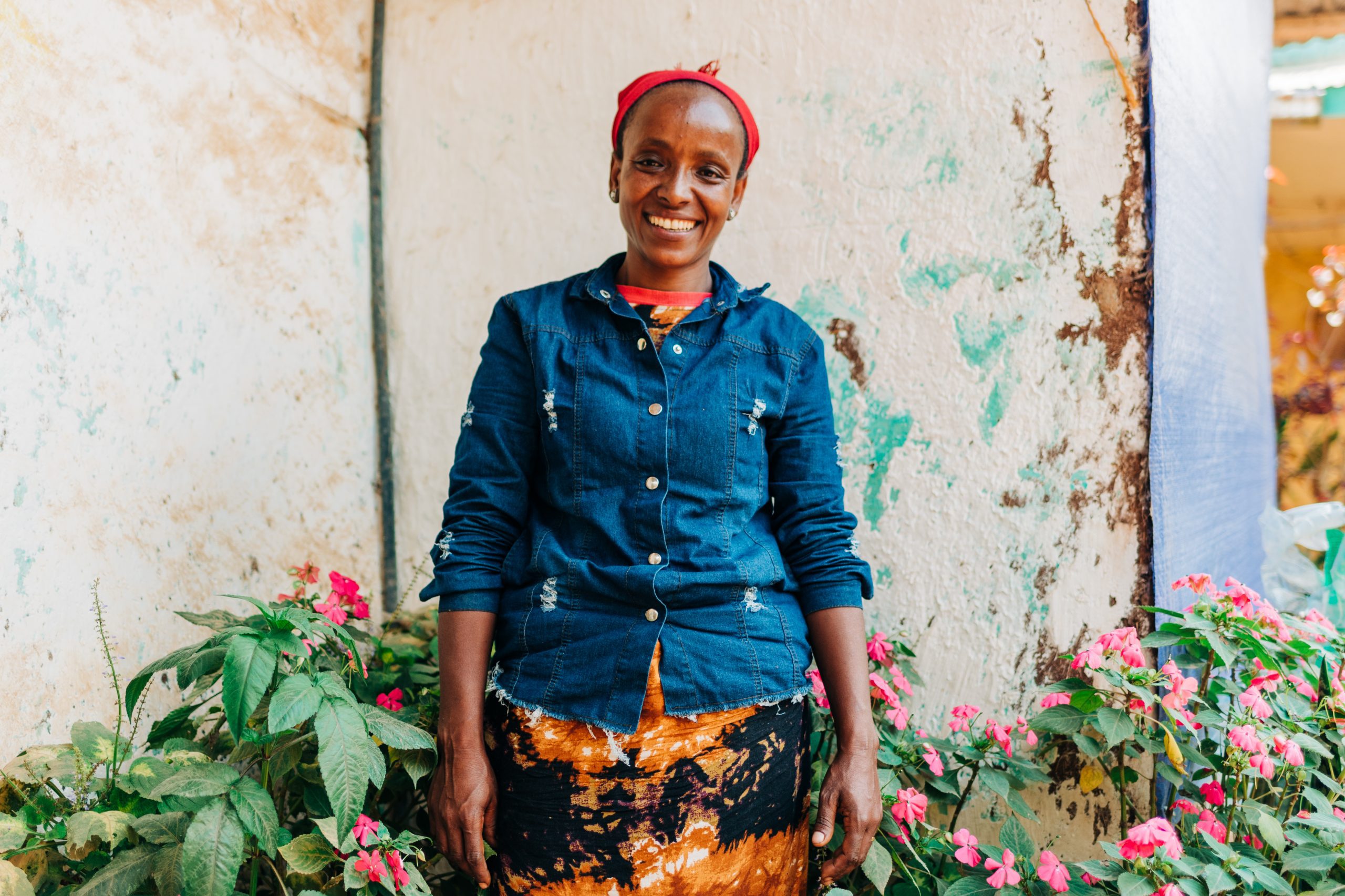 Women Leaders like Lubaba Mekonnen, a coffee farmer in Ethiopia, stands outside her house.