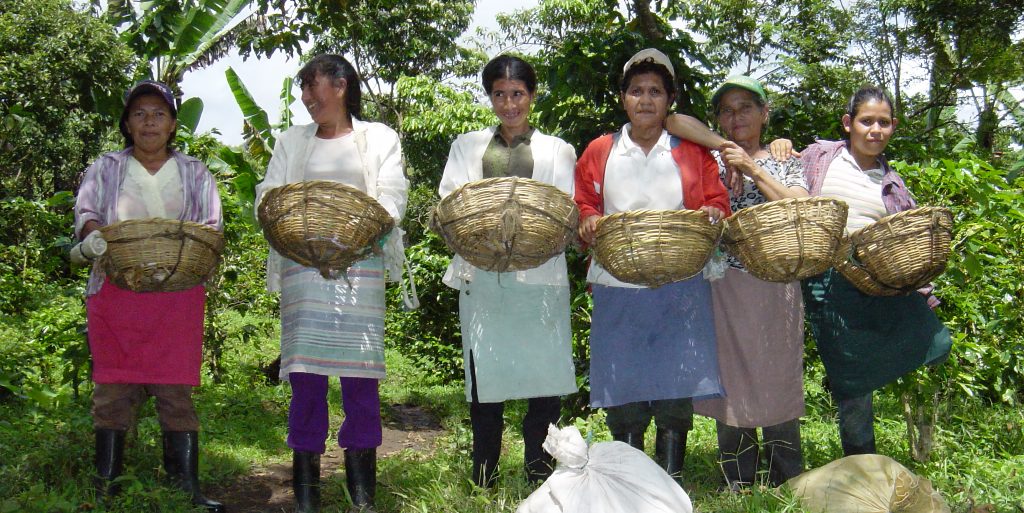 gender equality women farmers in Nicaragua holding baskets and smiling at camera