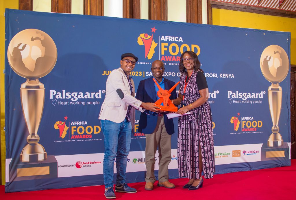 TechnoServe leadership receive a trophy on-stage at the Africa Food Awards