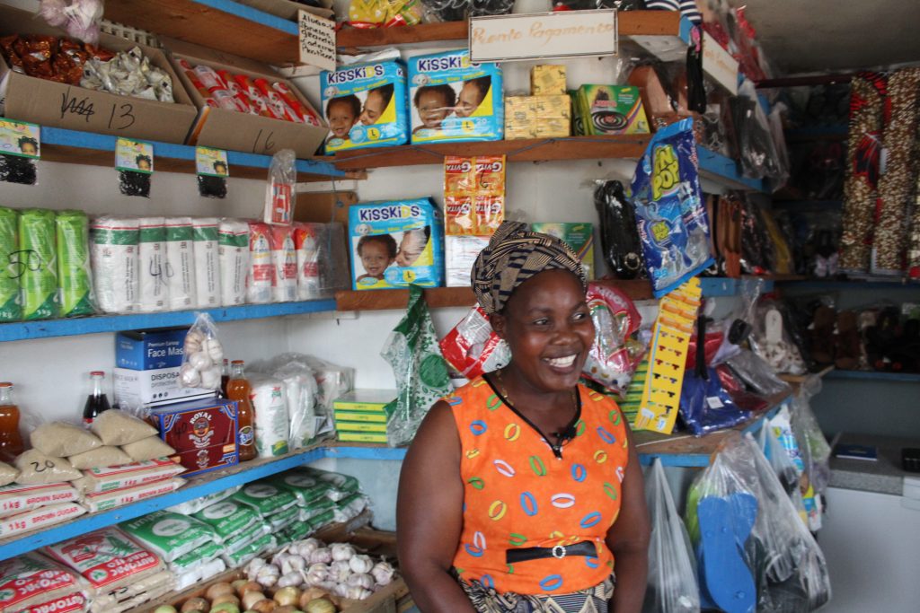 A woman stands in her shop in Mozambique. 