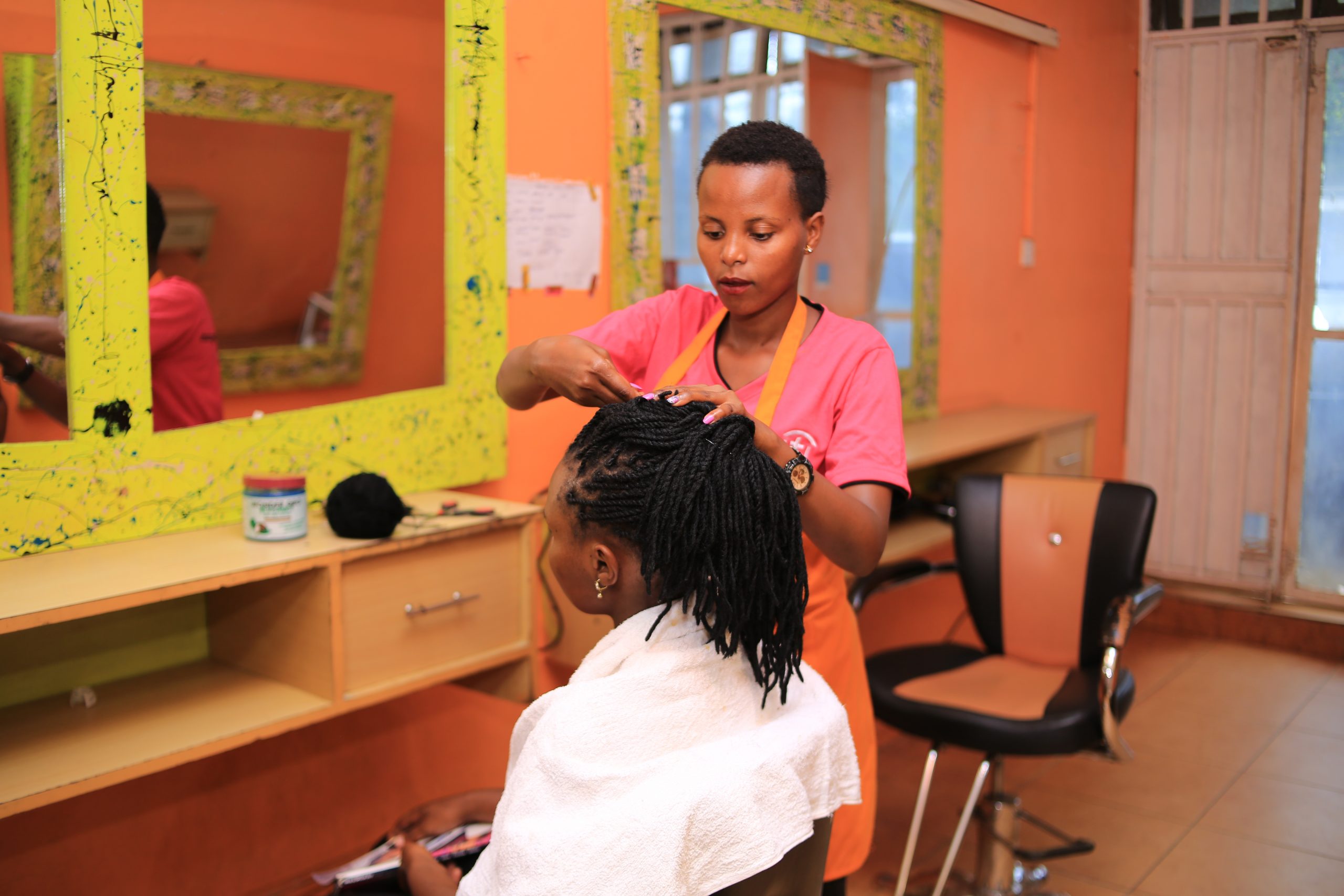 Carolyn works on a client in her salon business near Kampala, Uganda