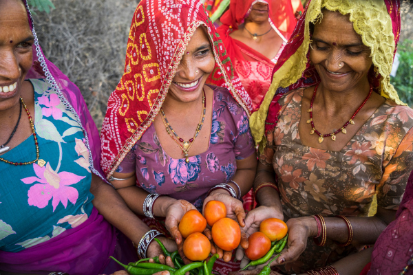 Women farmers in India holding produce despite the effects of climate change
