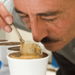 Man smelling and inspecting coffee in cup