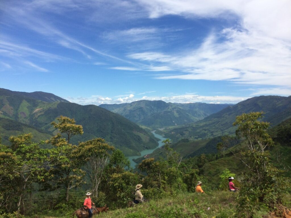 Farmers walk across a landscape in Colombia