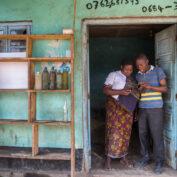 Two people standing in front of a shop in Kenya. Part of a blog post on AI in small business.